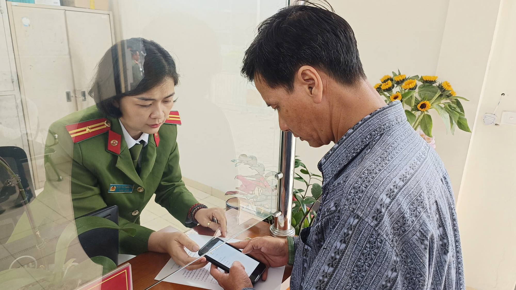 Thiếu tá Trà hướng dẫn công dân làm thủ tục hành chính. Ảnh: Thanh Hà Thiếu tá Trà hướng dẫn công dân làm thủ tục hành chính. Ảnh: Thanh Hà