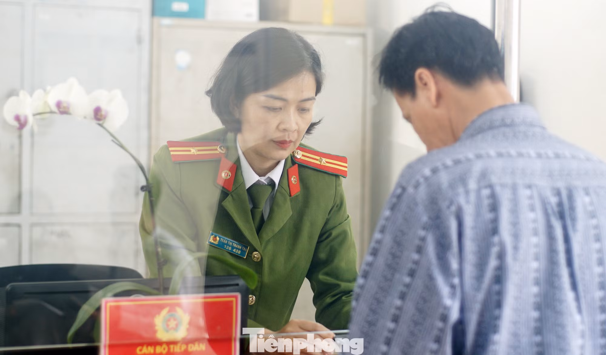 Thiếu tá Trà hướng dẫn công dân làm thủ tục hành chính. Ảnh: Thanh Hà