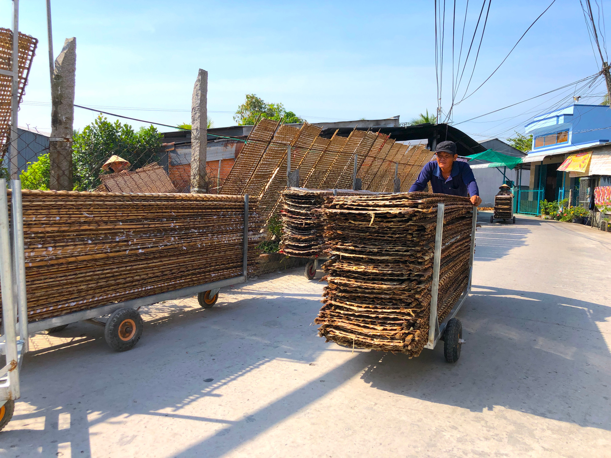 Nhân công thu các vỉ về sau khi bánh tráng đã đủ độ khô - Ảnh: Kim Hà. Nhân công thu các vỉ về sau khi bánh tráng đã đủ độ khô - Ảnh: Kim Hà.