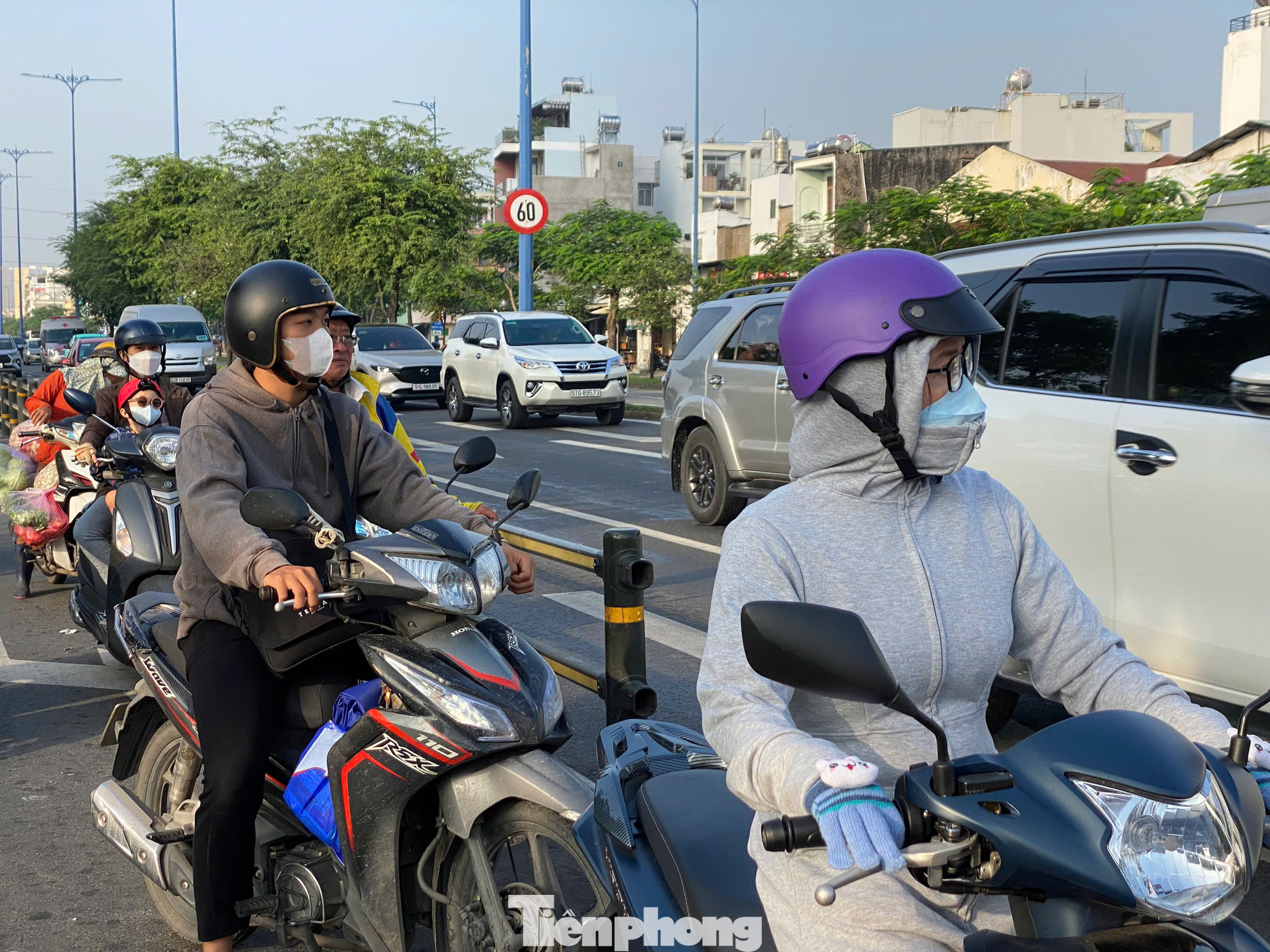 Người dân mặc áo ấm, đeo bao tay để giữ ấm khi ra đường. Ảnh: Hữu Huy