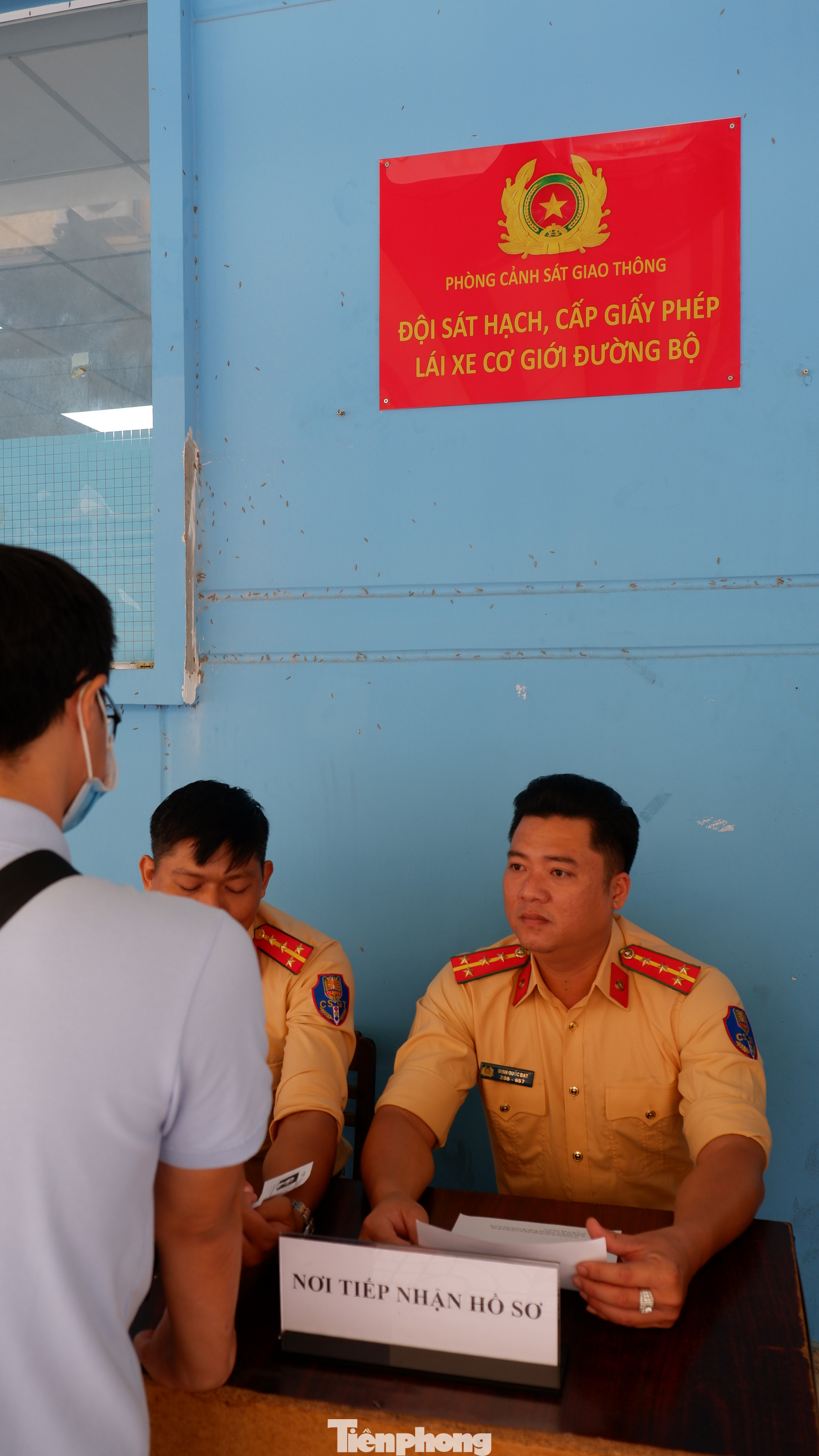 Cán bộ CSGT túc trực bên ngoài để tiếp nhận hồ sơ và hướng dẫn, giải đáp thắc mắc cho người dân.