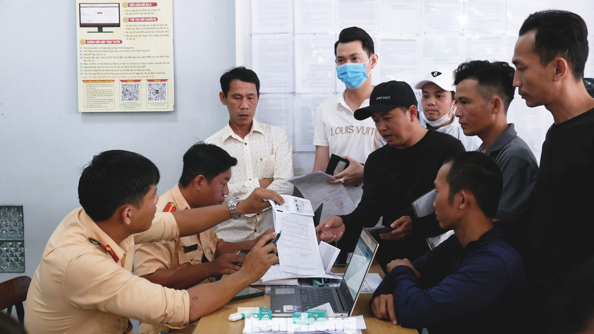 Cán bộ CSGT hướng dẫn người dân làm hồ sơ cấp đổi giấy phép lái xe. Cán bộ CSGT hướng dẫn người dân làm hồ sơ cấp đổi giấy phép lái xe.