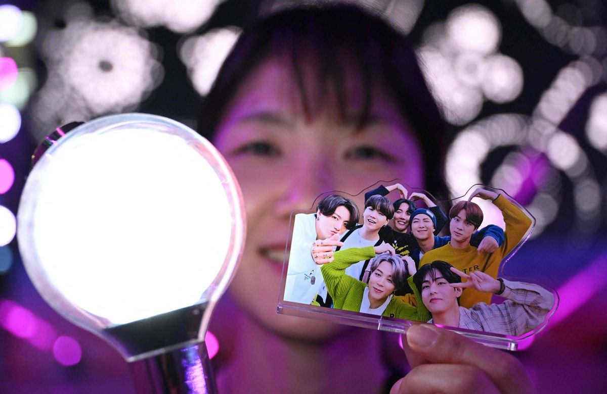 Một người hâm mộ nhóm nhạc nam K-pop BTS cầm light stick chính thức và ảnh các thành viên BTS trong sự kiện BTS FESTA thường niên kỷ niệm ngày ra mắt của nhóm tại trung tâm triển lãm KINTEX ở Goyang, tỉnh Gyeonggi, ngày 13/6.