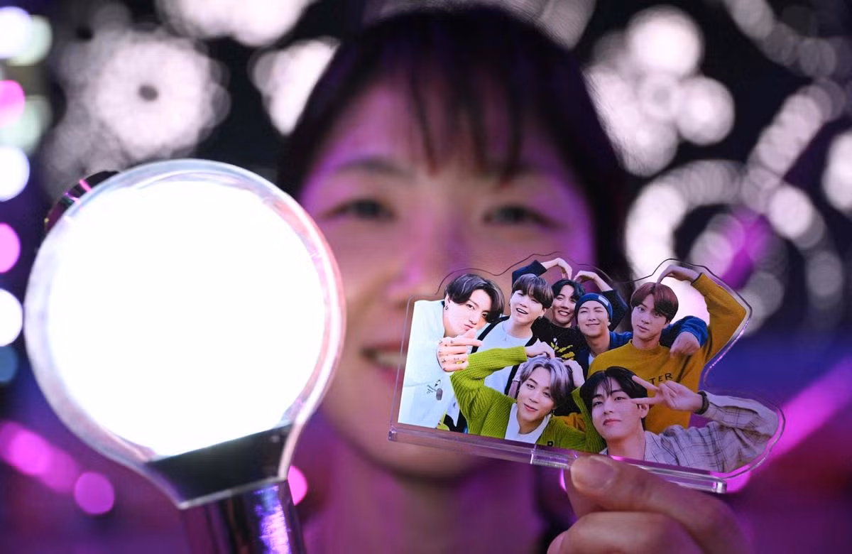 Một người hâm mộ nhóm nhạc nam K-pop BTS cầm light stick chính thức và ảnh các thành viên BTS trong sự kiện BTS FESTA thường niên kỷ niệm ngày ra mắt của nhóm tại trung tâm triển lãm KINTEX ở Goyang, tỉnh Gyeonggi, ngày 13/6.