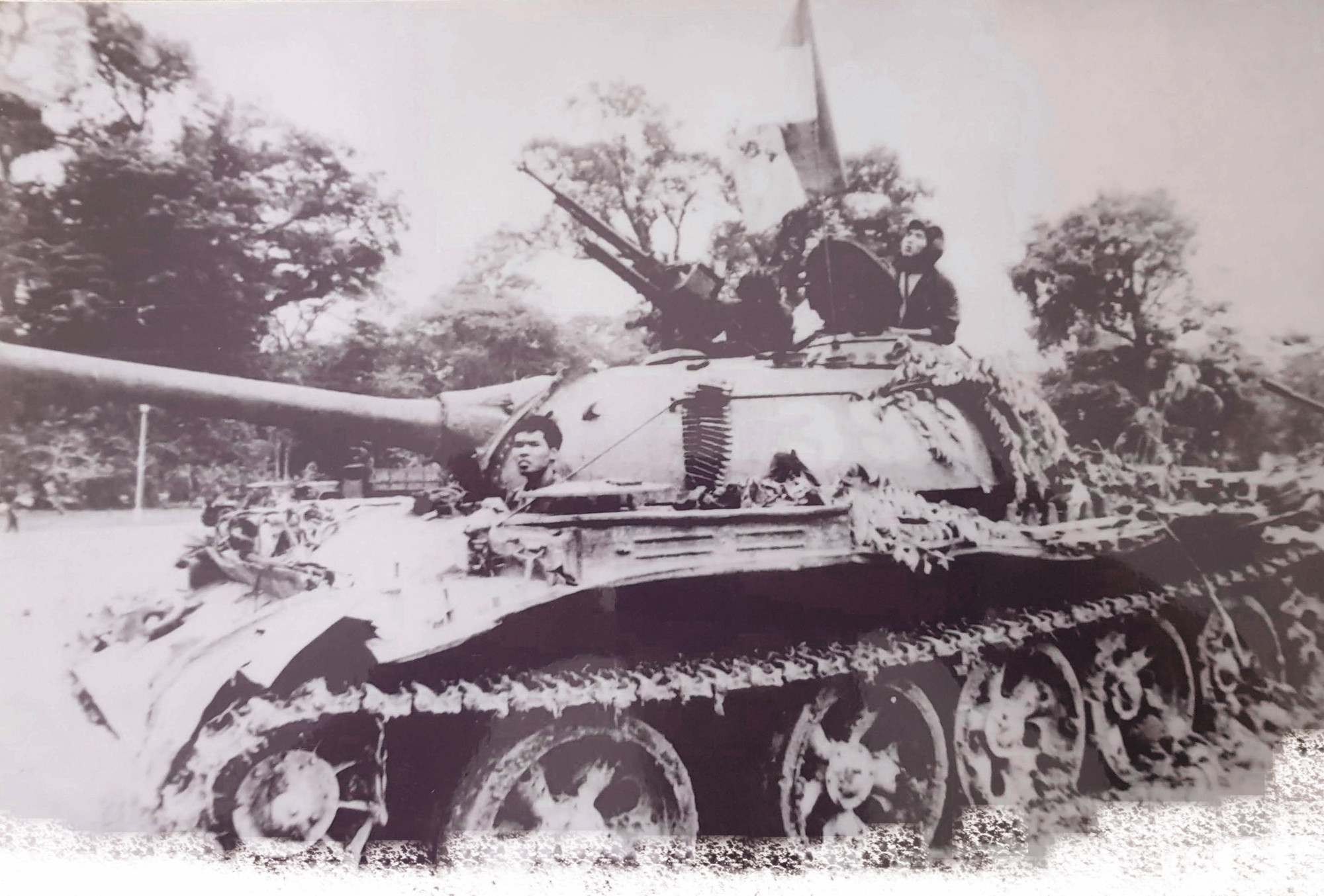 Xe tăng 390 tại Dinh Độc Lập ngày 30/4/1975, lái xe Nguyễn Văn Tập ngồi phía trước nhô đầu khỏi xe, pháo thủ Ngô Sỹ Nguyên nhô người trên tháp pháo xe tăng Ảnh: FRANCOISE DEMULDER