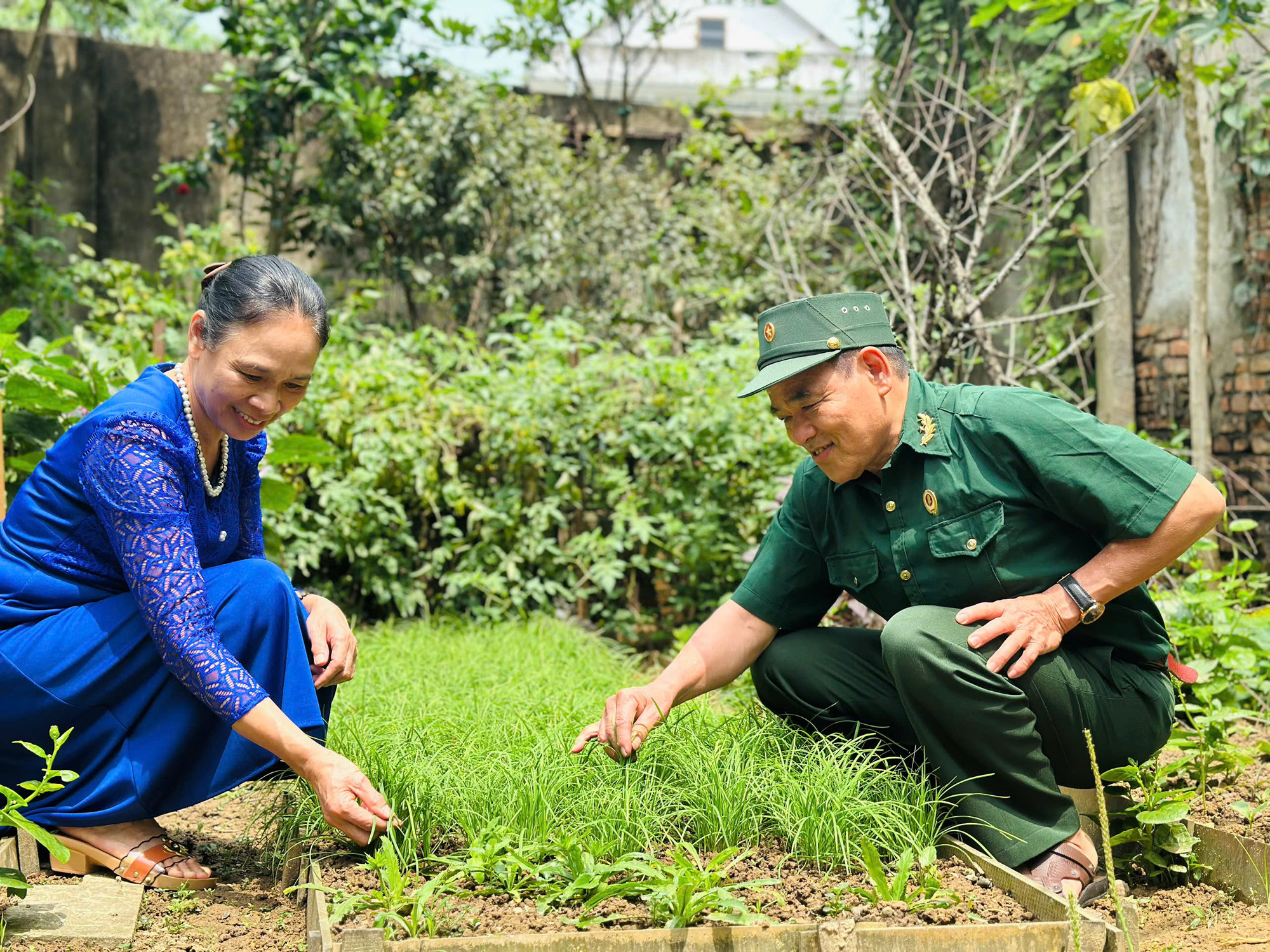 Ông Dân cùng vợ chăm sóc vườn rau.