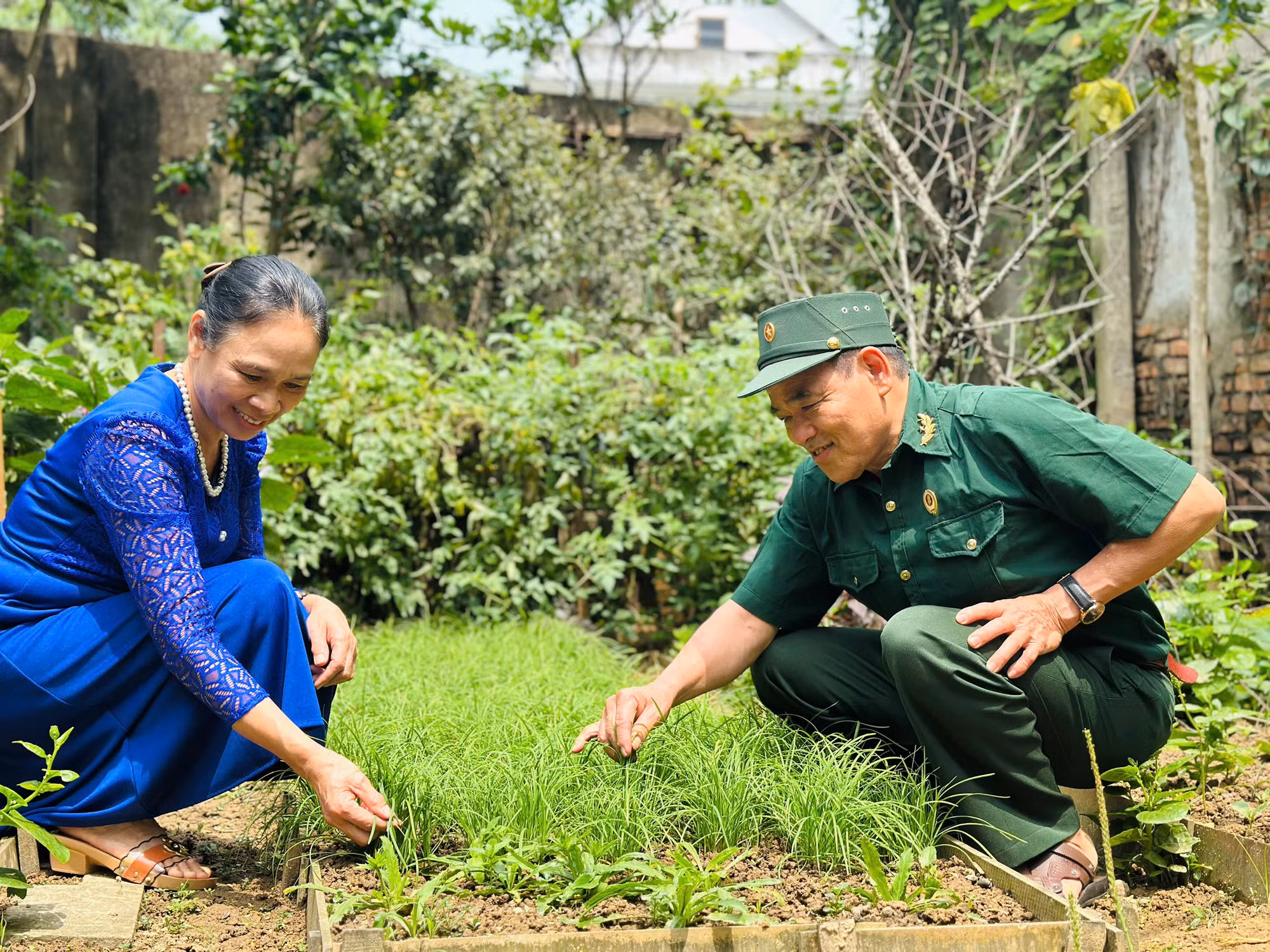 Ông Dân cùng vợ chăm sóc vườn rau.
