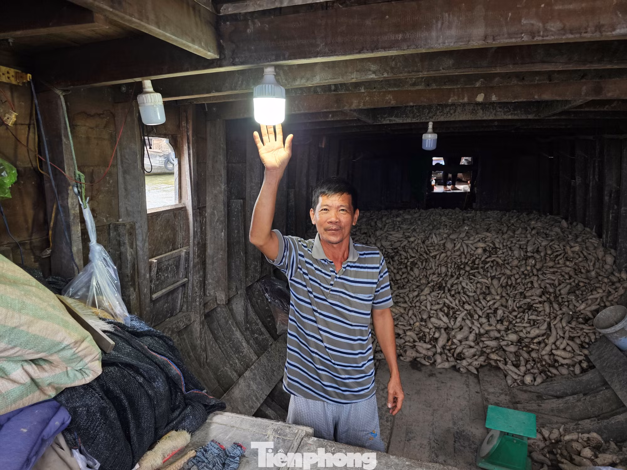 Ông Lâm Văn Phong ở chợ nổi Cái Răng bên ánh đèn được thắp sáng từ năng lượng mặt trời. Ảnh: Hòa Hội. Ông Lâm Văn Phong ở chợ nổi Cái Răng bên ánh đèn được thắp sáng từ năng lượng mặt trời. Ảnh: Hòa Hội.