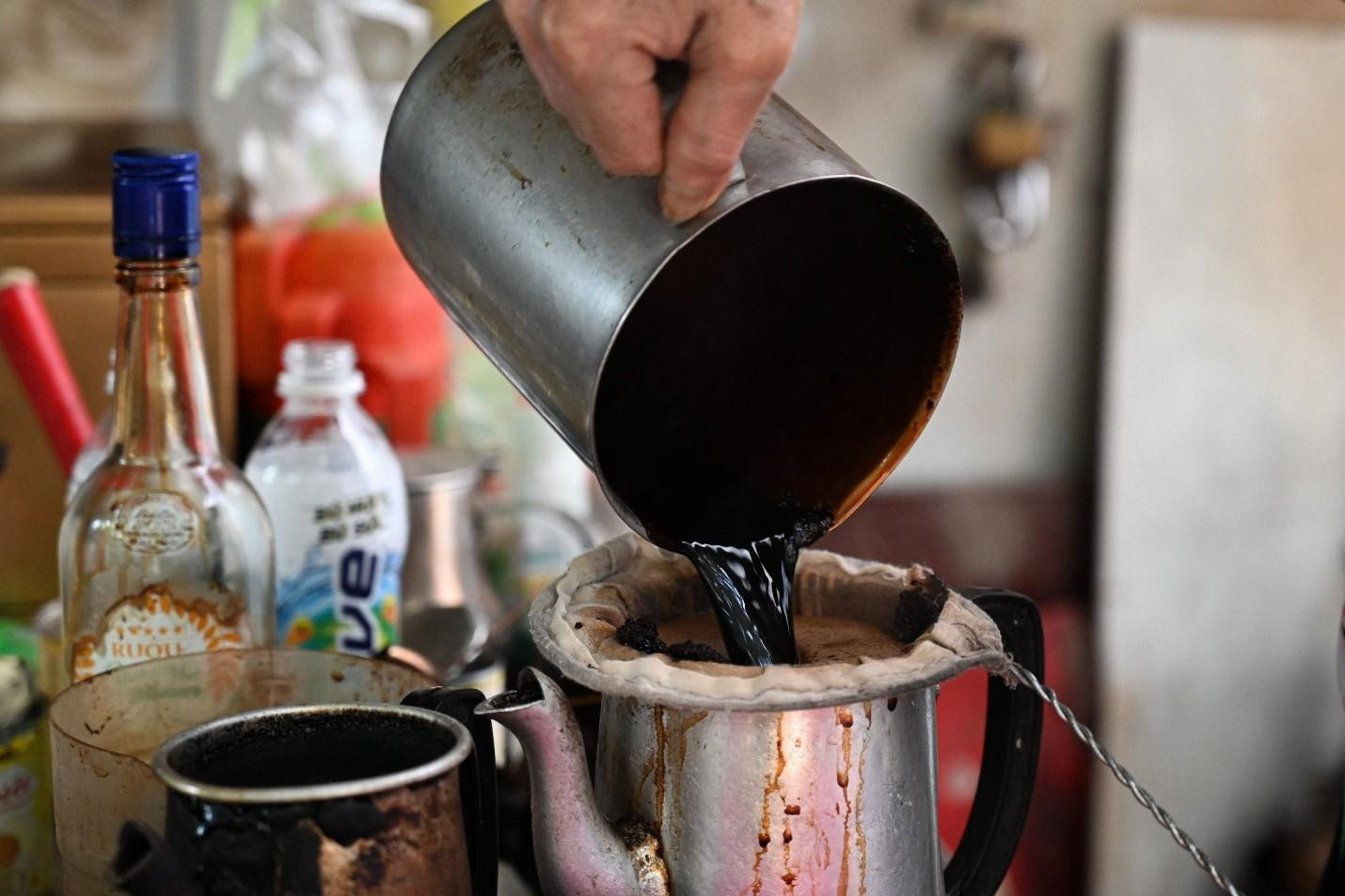 Ủ một vài phút rồi đánh chín cà phê, bỏ lại vào ấm nhôm sau đó chế vào ly cho khách, vậy là đã có một ly cà phê vợt đúng vị -ảnh Huỳnh Như