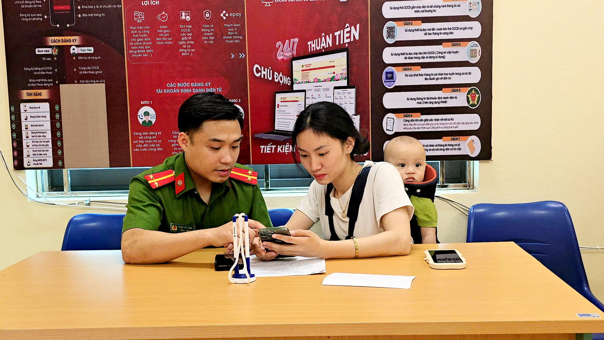 Cán bộ công an xã hướng dẫn người dân làm thủ tục trên smartphone Cán bộ công an xã hướng dẫn người dân làm thủ tục trên smartphone