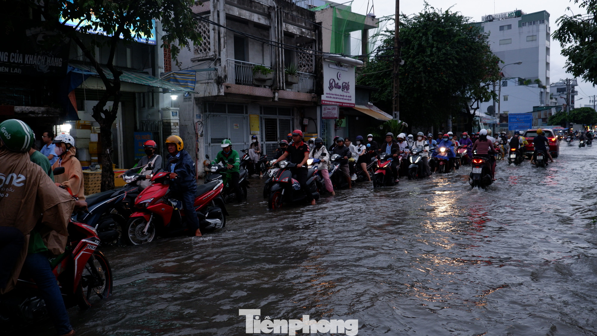 Dòng xe xếp hàng di chuyển qua điểm ngập sâu trên đường Trần Xuân Soạn. Dòng xe xếp hàng di chuyển qua điểm ngập sâu trên đường Trần Xuân Soạn.