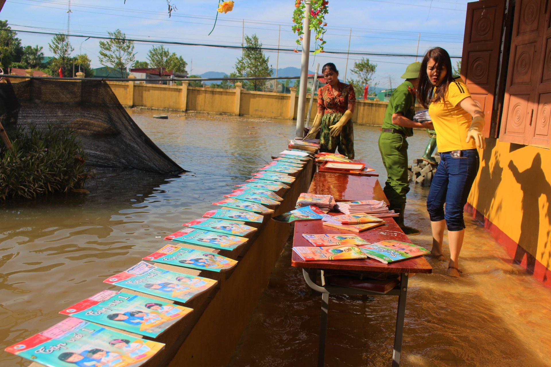 Lũ rút, giáo viên lội nước cao nửa mét vào trường mò tìm sách cho trò