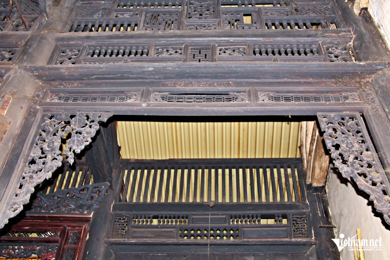 Bên trên hệ thống cột gỗ còn chắc chắn, lên nước đen bóng là những bức vách chạm lộng tinh xảo. Ảnh: Hà Nguyễn. Bên trên hệ thống cột gỗ còn chắc chắn, lên nước đen bóng là những bức vách chạm lộng tinh xảo. Ảnh: Hà Nguyễn.