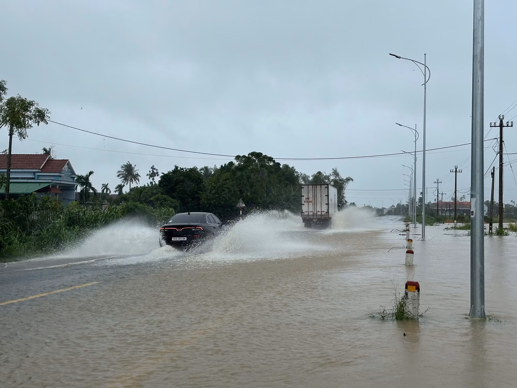 Nước trên sông Trà Câu dâng cao tràn qua Quốc lộ 1A.