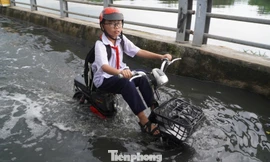 Triều cường dâng cao, người dân TPHCM vất vả lội nước về nhà 