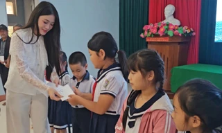 Người đẹp Phùng Thị Hương Giang trao quà cho các em học sinh bị ảnh hưởng bởi lũ lụt.