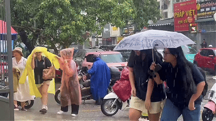Tình nguyện viên dầm mưa tiếp sức thí sinh đến làm thủ tục ở TPHCM