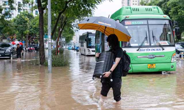 Người dân xắn quần bì bõm vác vali, dắt xe vượt 'biển nước' trên đường Võ Chí Công