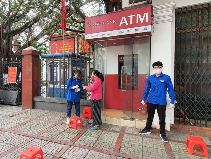 Thanh niên Hải Phòng nhắc người dân giữ khoảng cách, rửa tay sát khuẩn tại cây ATM ảnh 2