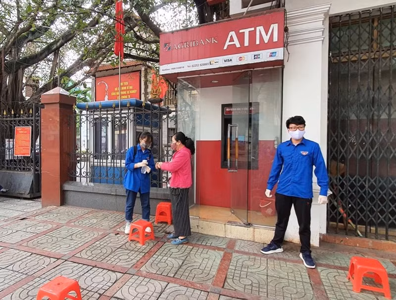 Thanh niên Hải Phòng nhắc người dân giữ khoảng cách, rửa tay sát khuẩn tại cây ATM ảnh 2