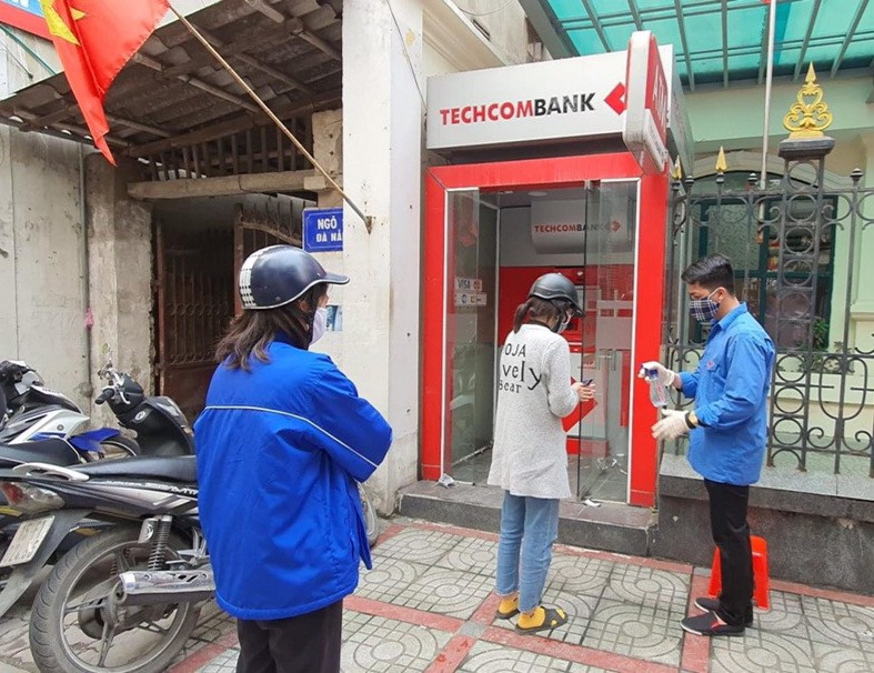 Thanh niên Hải Phòng nhắc người dân giữ khoảng cách, rửa tay sát khuẩn tại cây ATM ảnh 1