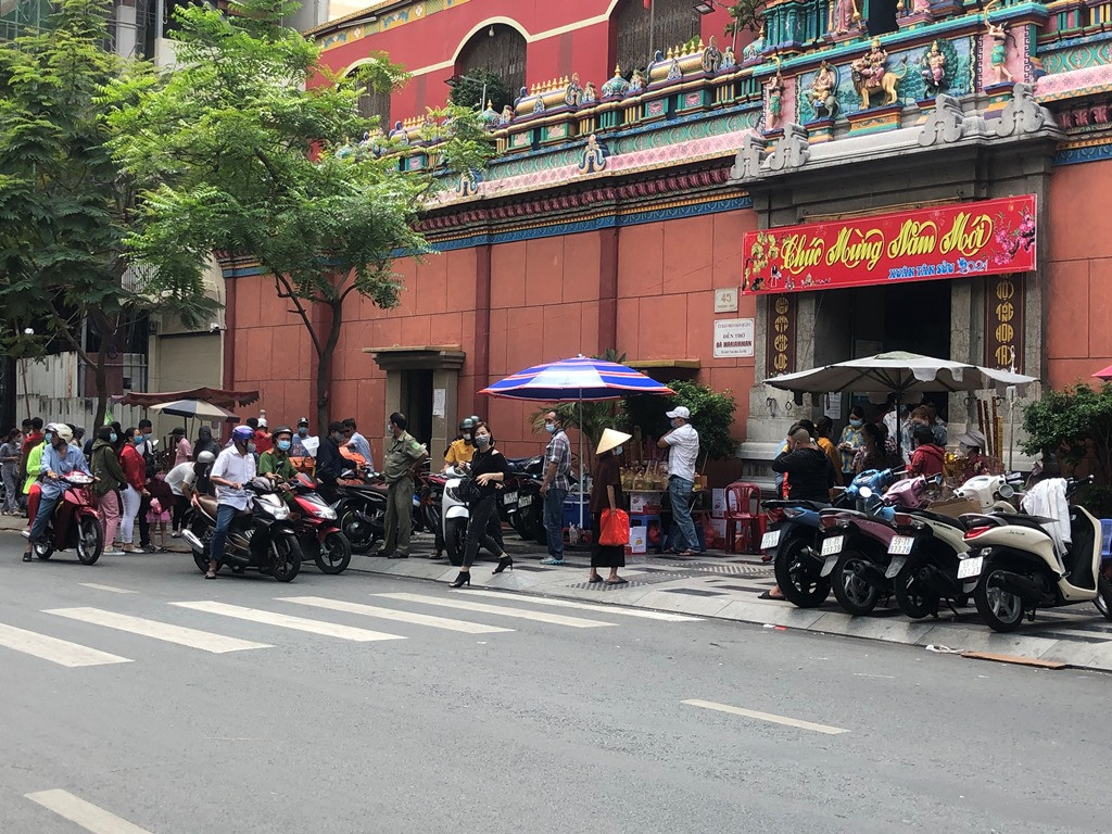 Sài Gòn nhộn nhịp trưa Mùng 1 Tết, dân đeo khẩu trang kín mít đi lễ chùa đầu năm ảnh 15