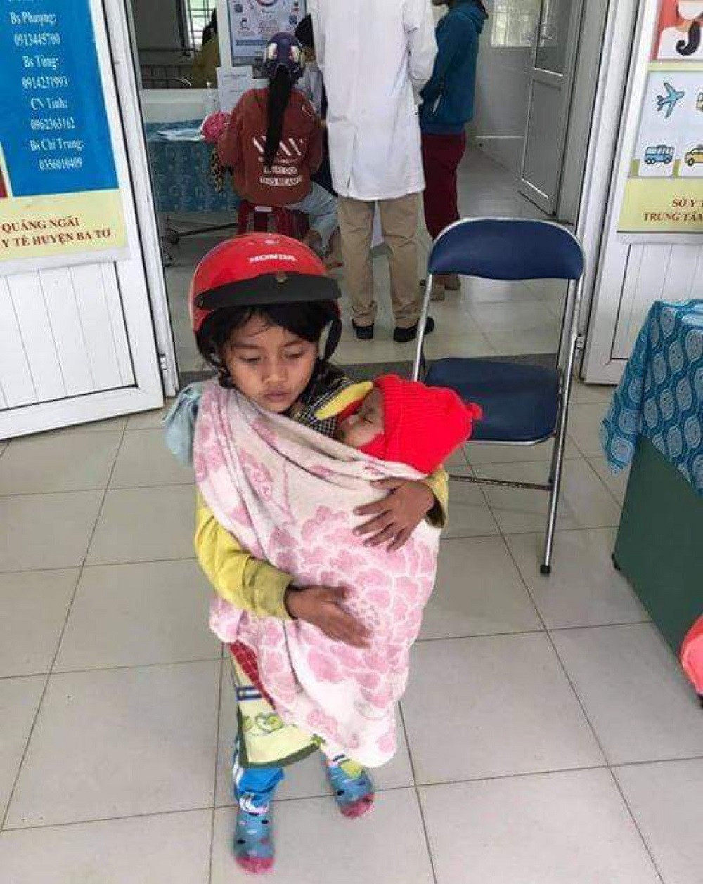 Xót xa hình ảnh bé gái 7 tuổi bế em đi tiêm phòng ảnh 1