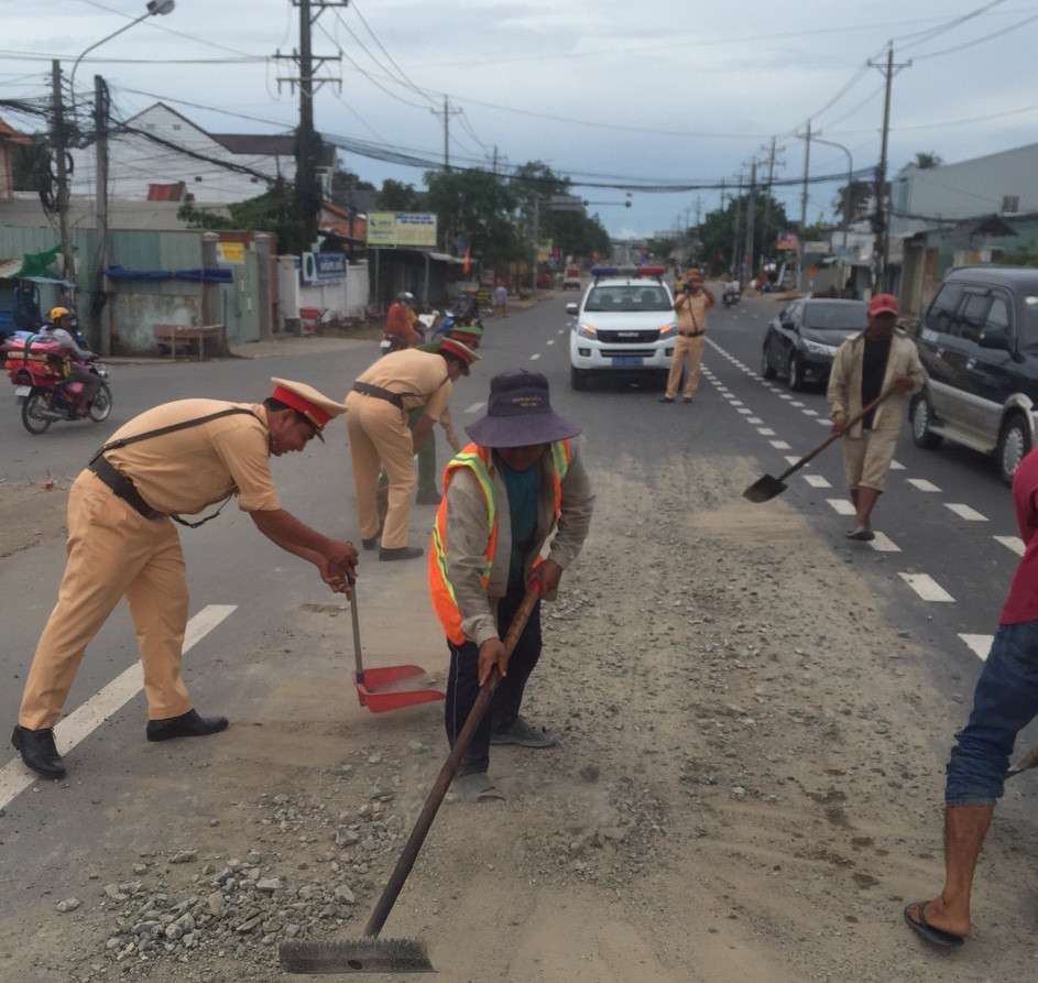 Cảnh sát giao thông cùng người dân nhặt đá trên đường tuần tra ảnh 1