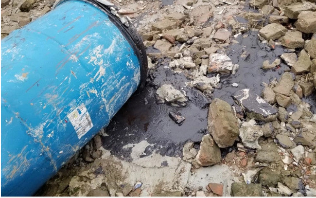 Hàng chục thùng phuy lạ rò rỉ chất đen xì mùi nồng nặc đổ xuống sông Hồng ảnh 1