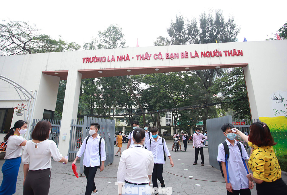 Học sinh đeo khẩu trang, chào cờ tại lớp học trong ngày đầu trở lại trường ảnh 1