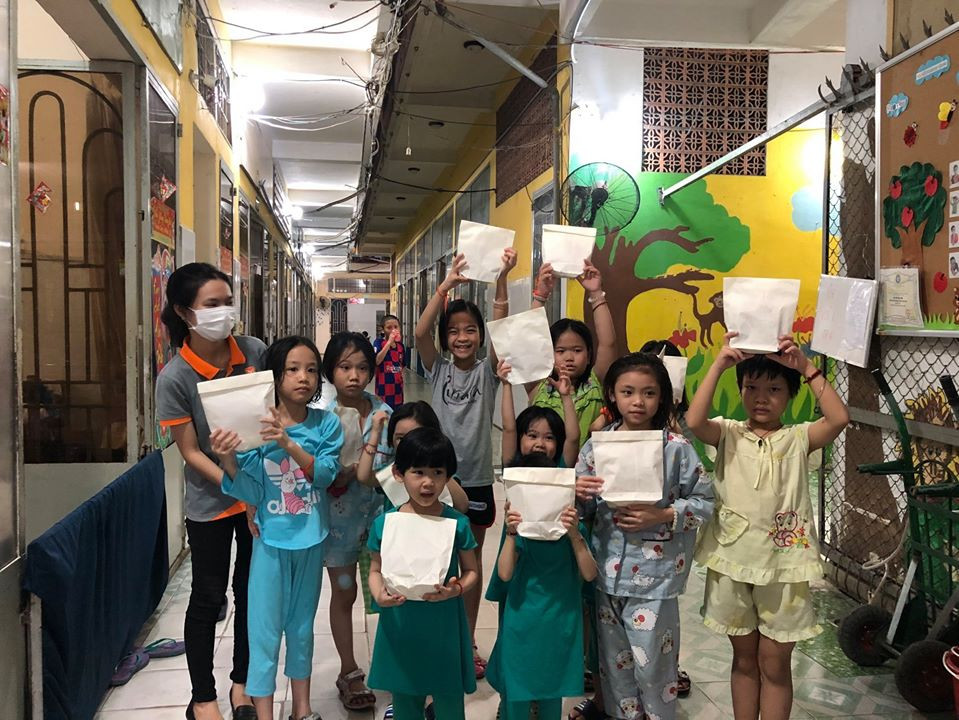 Các em nhỏ đón nhận những chiếc bánh hoa cúc thơm phức mùi bơ. Người trẻ Sài Gòn tiếp lửa trong cuộc chiến chống dịch COVID-19 với món quà hương hoa cúc ảnh 4