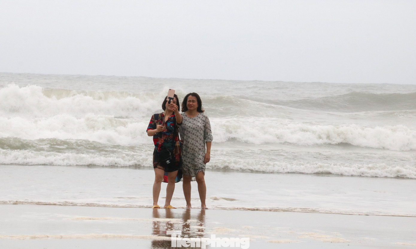 Mặc sóng lớn sau bão, người dân vẫn ra biển câu cá, chụp hình ảnh 7