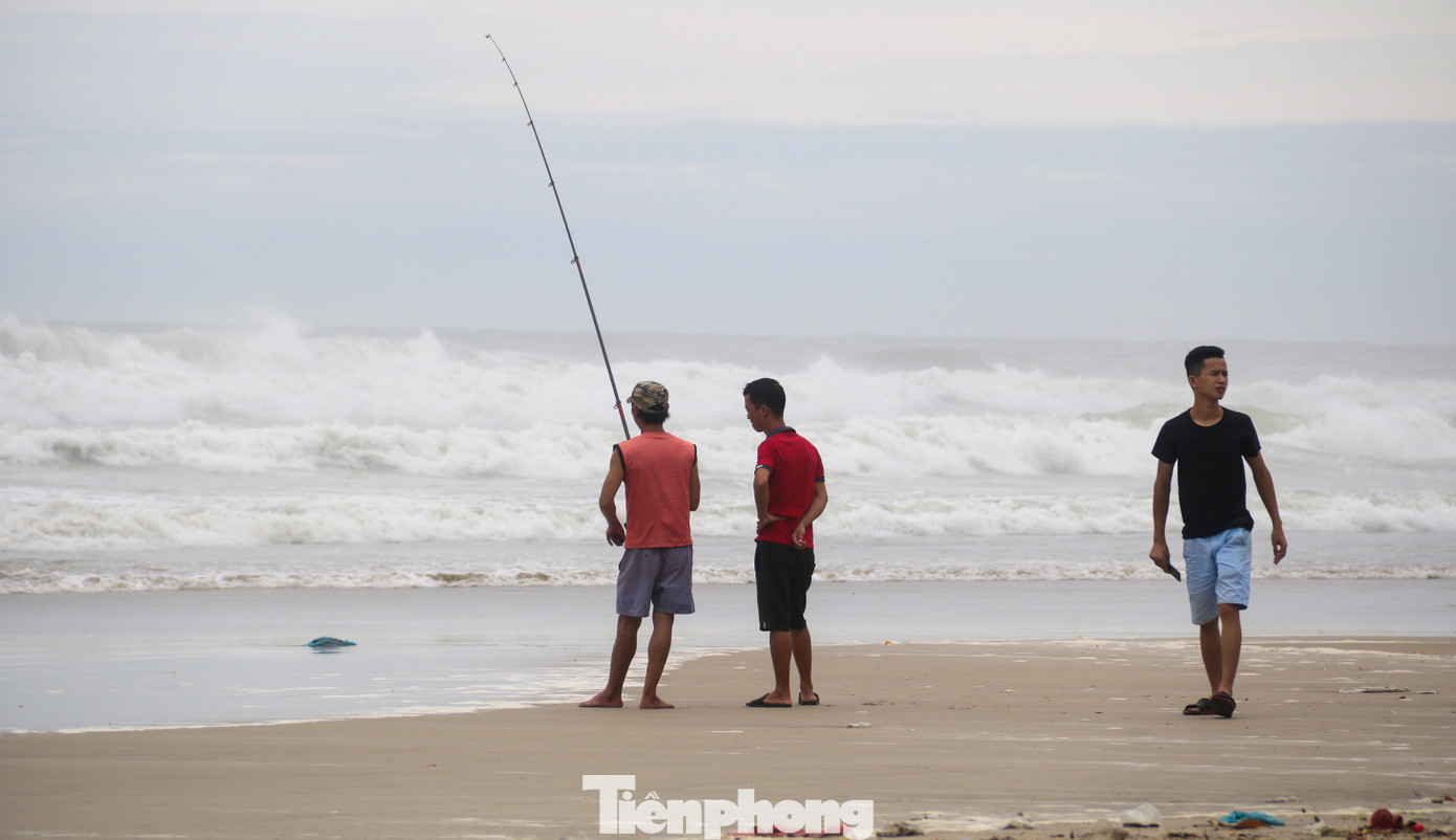 Mặc sóng lớn sau bão, người dân vẫn ra biển câu cá, chụp hình ảnh 5