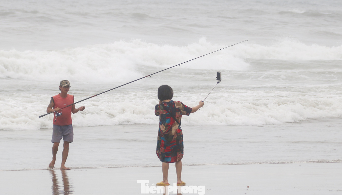 Mặc sóng lớn sau bão, người dân vẫn ra biển câu cá, chụp hình ảnh 9
