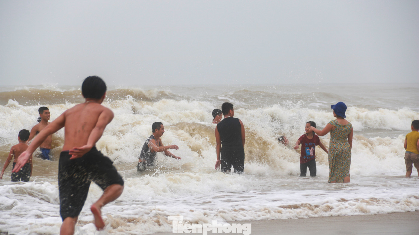 Biển động sóng cao phủ đầu, người dân Đà Nẵng vẫn liều mình tắm biển sau bão ảnh 1