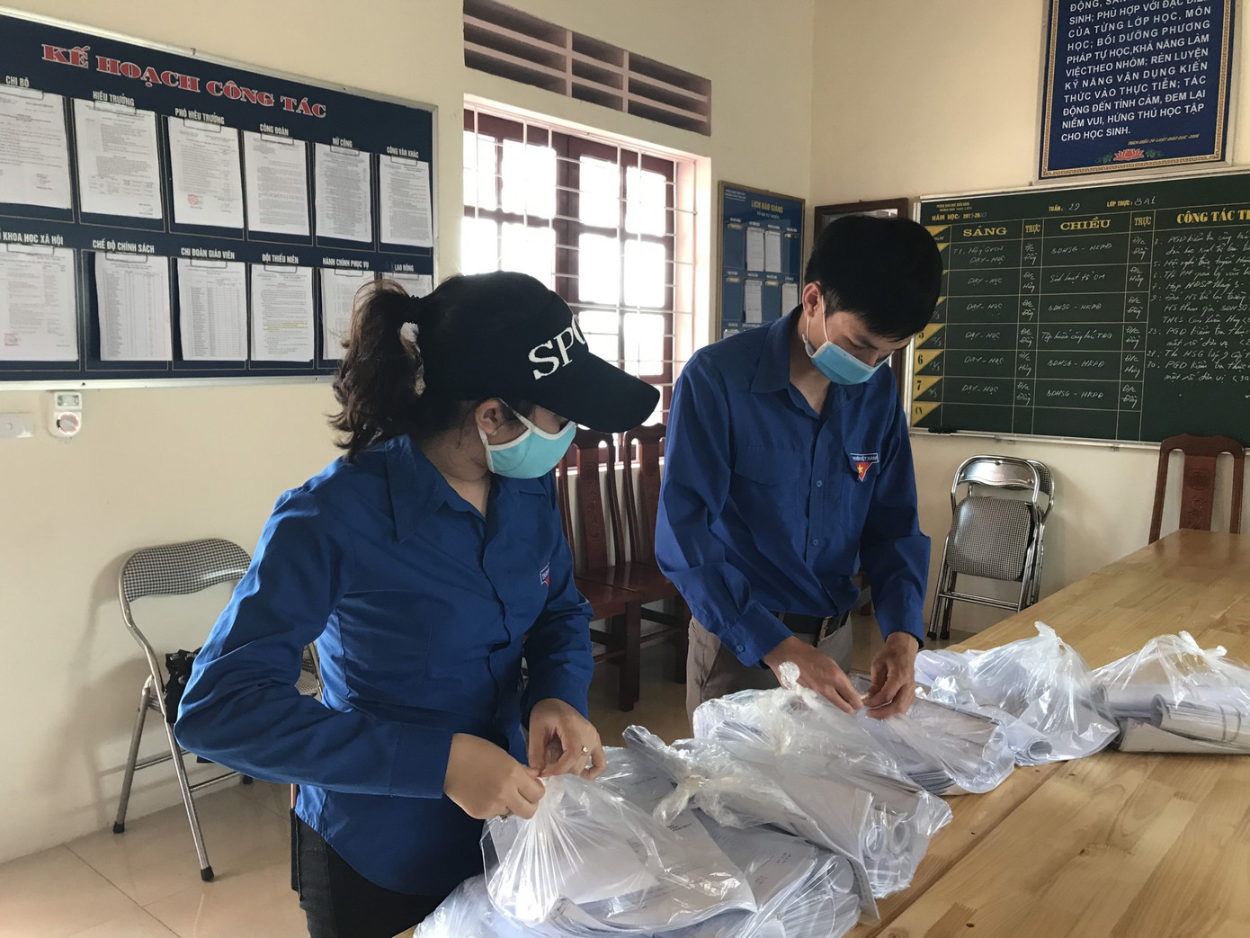 Các tình nguyện viên phân loại bài tập. Nghỉ học vì COVID-19, các 'shipper áo xanh” mang bài đến tận nhà cho học sinh ảnh 3