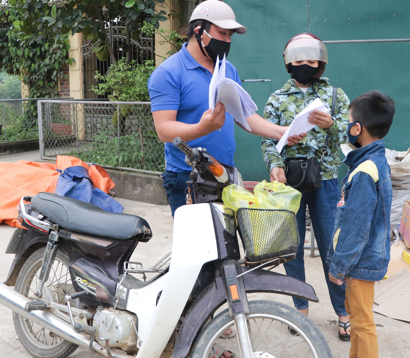 Hình ảnh màu áo xanh tình nguyện có ở mọi nơi. Nghỉ học vì COVID-19, các 'shipper áo xanh” mang bài đến tận nhà cho học sinh ảnh 5