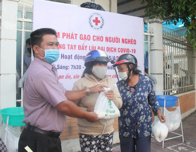 Đại diện ban tổ chức trao tận tay gạo cho người dân. Ảnh Thành Nguyễn/Báo Khánh Hoà. ATM phát gạo cho người nghèo Nha Trang chuyển địa điểm vì quá tải ảnh 2