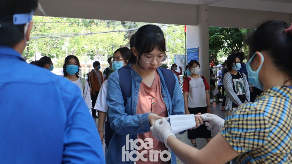 Phát khẩu trang y tế cho thí sinh - Ảnh: Ngọc Trâm Đà Nẵng: Sĩ tử “check-in” địa điểm dự thi Tốt nghiệp THPT, công tác chuẩn bị đã sẵn sàng ảnh 1
