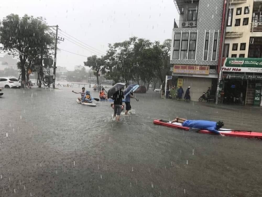 Nước hồ tràn bờ, đường Hàm Nghi hóa thành sông. Nhiều người dân đổ ra đường chèo thuyền, bắt cá (Ảnh: Tuổi trẻ Công an TP Đà Nẵng) Đường phố Đà Nẵng hóa sông, người dân đổ ra chèo thuyền, bắt cá mặc thành phố can ngăn ảnh 4