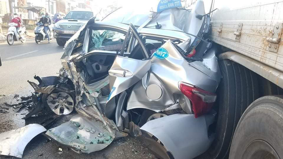 Taxi nát bét sau khi bị cuốn vào gầm xe tải ảnh 1