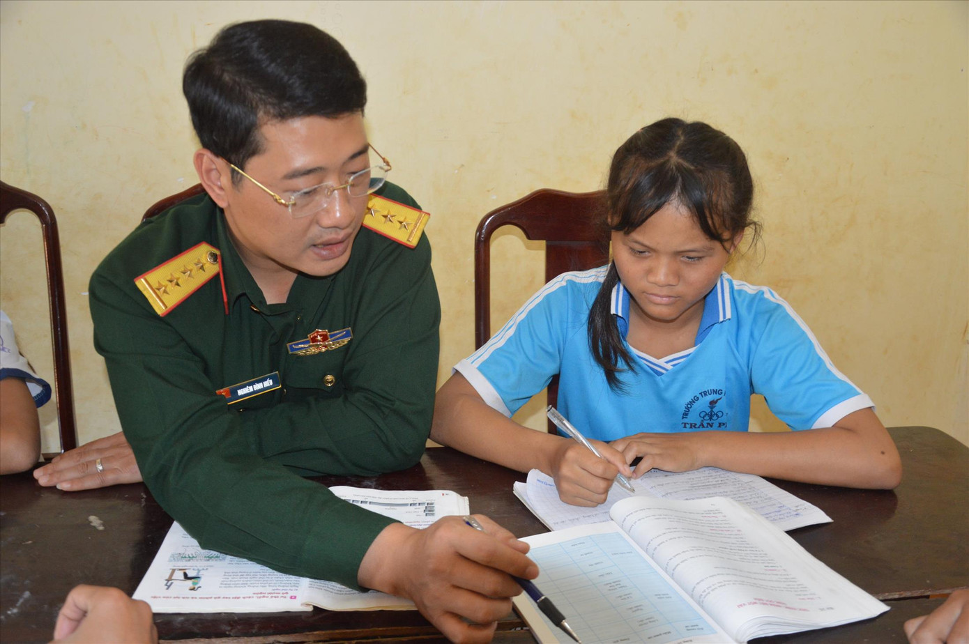 Đại úy Nghiêm Đình Hiếu dạy học cho em nhỏ mồ côi được Trung đoàn 720 nhận nuôi dưỡng Ảnh: NVCC Cống hiến tài năng, lan tỏa yêu thương ảnh 1