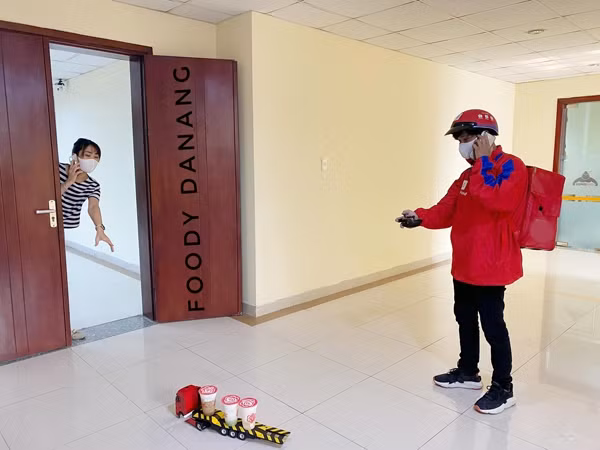 Phòng lây nhiễm mùa dịch, shipper giao đồ ăn cho khách hàng bằng xe đồ chơi ảnh 5