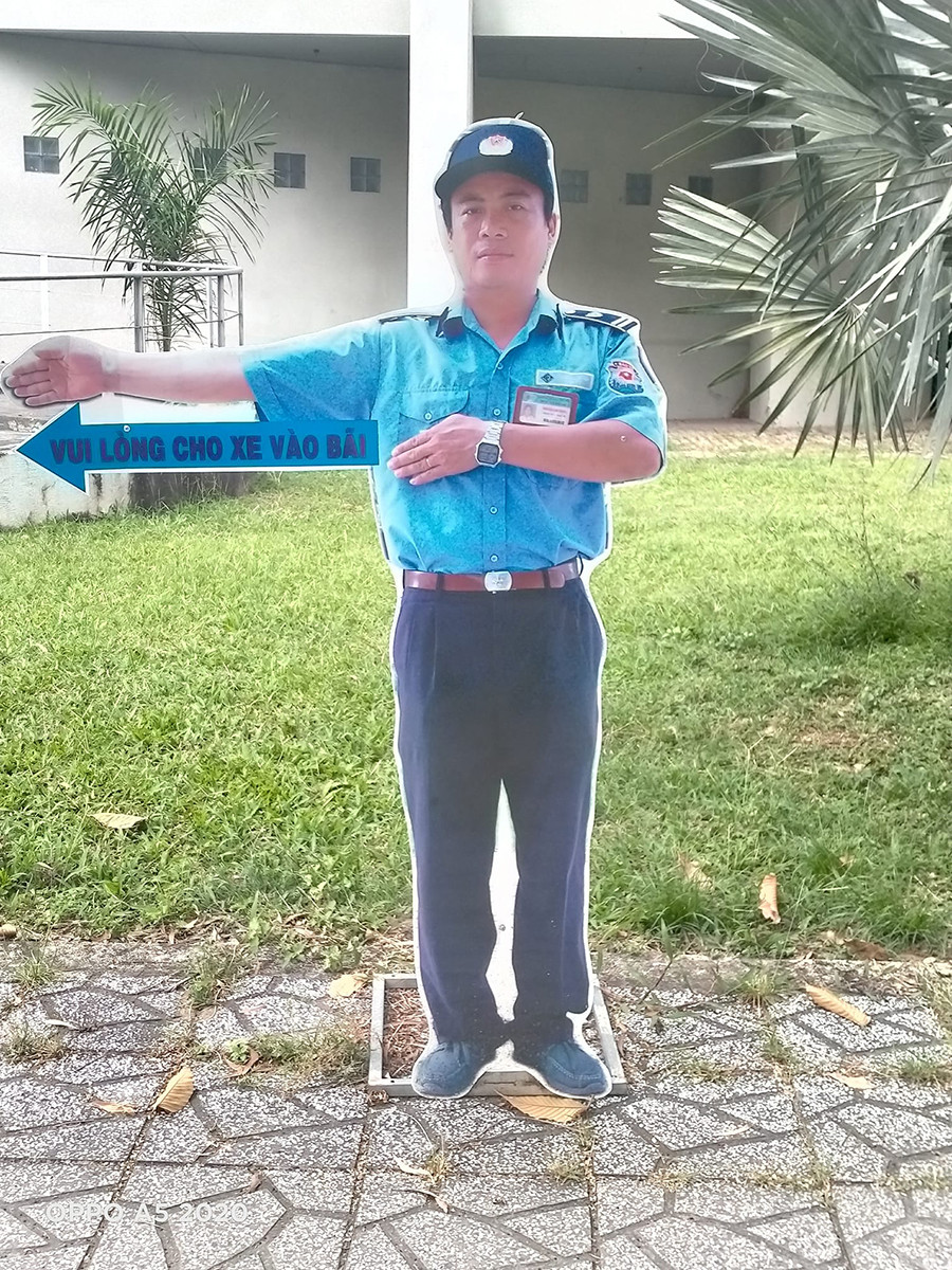 Bác bảo vệ siêu có tâm: Dựng standee chân dung của mình để chỉ dẫn sinh viên hướng để xe ảnh 1