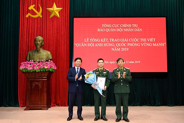 Ông Trần Thanh Lâm, Cục trưởng Cục Báo chí-Xuất bản, Ban Tuyên giáo Trung ương và Thiếu tướng Phạm Văn Huấn TBT báo Quân đội nhân dân trao giải nhất cho tác giả. Ảnh: Thái Hưng Nhà văn Đỗ Bích Thúy giành giải thưởng thi viết về quân đội và quốc phòng ảnh 1