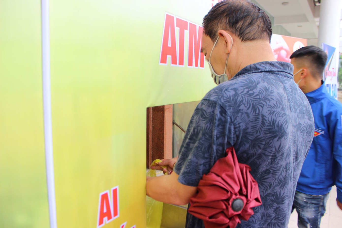 Người dân đến nhận gạo tại "ATM gạo". Ấm lòng 'ATM gạo' và siêu thị '0 đồng' hỗ trợ người dân trong mùa dịch ảnh 1