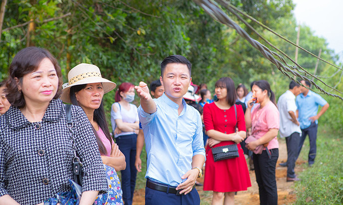 Bùi Đức Tuyển (áo xanh) thuyết minh về mô hình của hợp tác xã với khách tham quan. Cất tấm bằng đại học, chàng trai rời thành phố về quê mở trang trại “tiền tỷ“ ảnh 3