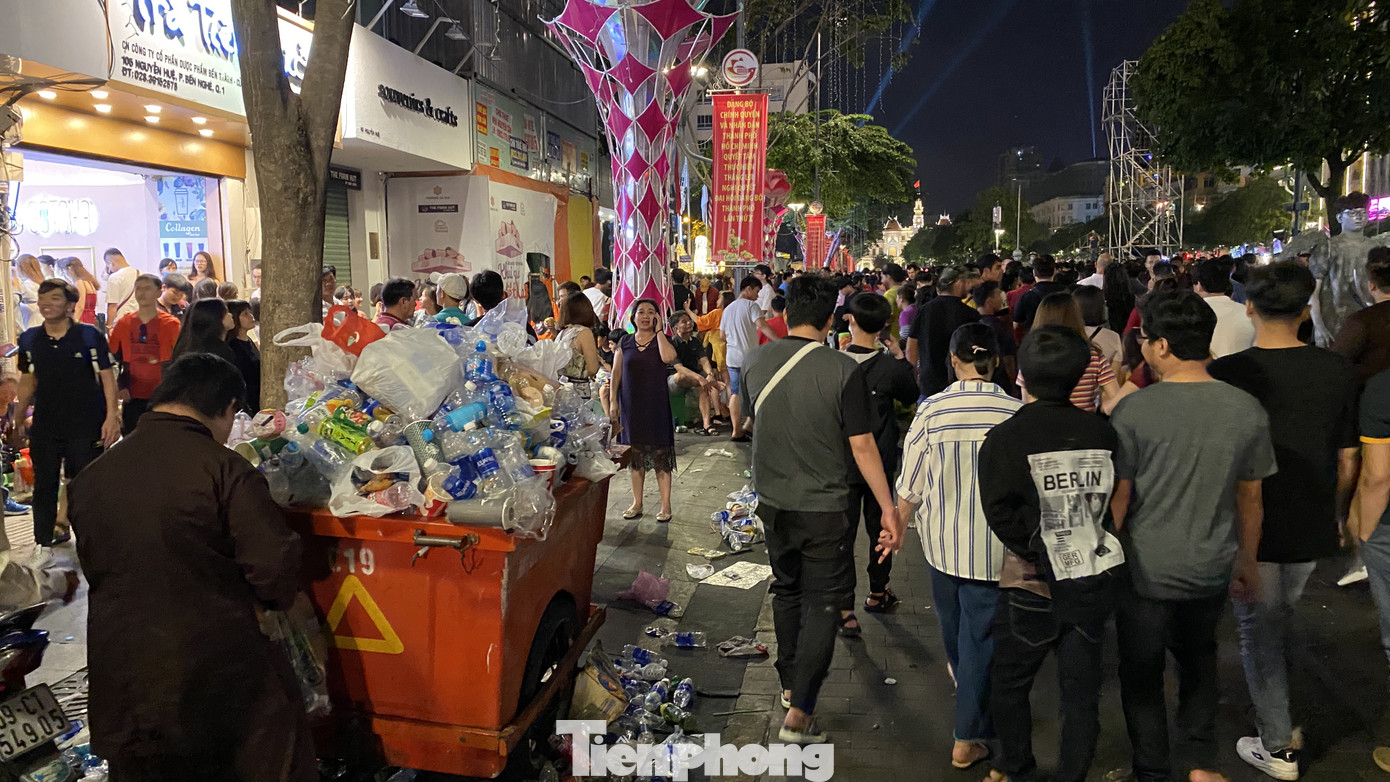 Ngổn ngang rác trên phố đi bộ Nguyễn Huệ sau màn bắn pháo hoa ảnh 1