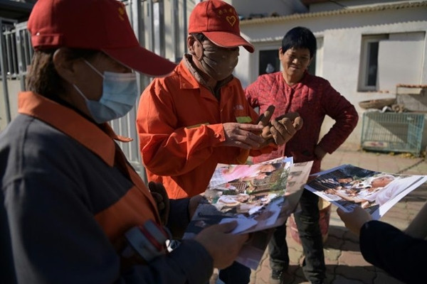 Dân làng xem lại ảnh 19 năm trước. Ảnh: AFP. Ảnh “ngày xưa - bây giờ” của một thanh niên khiến ai cũng ấn tượng, vì có cả ông Joe Biden ảnh 2