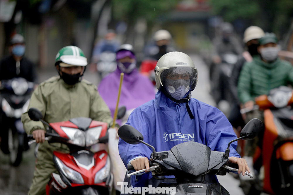 Tại ngã tư phố Cửa Nam, lượng người đổ về trung tâm Thành phố Hà Nội làm việc cũng khá đông. Người Hà Nội hối hả đội mưa đi làm tuần thứ hai 'cách ly toàn xã hội' ảnh 5